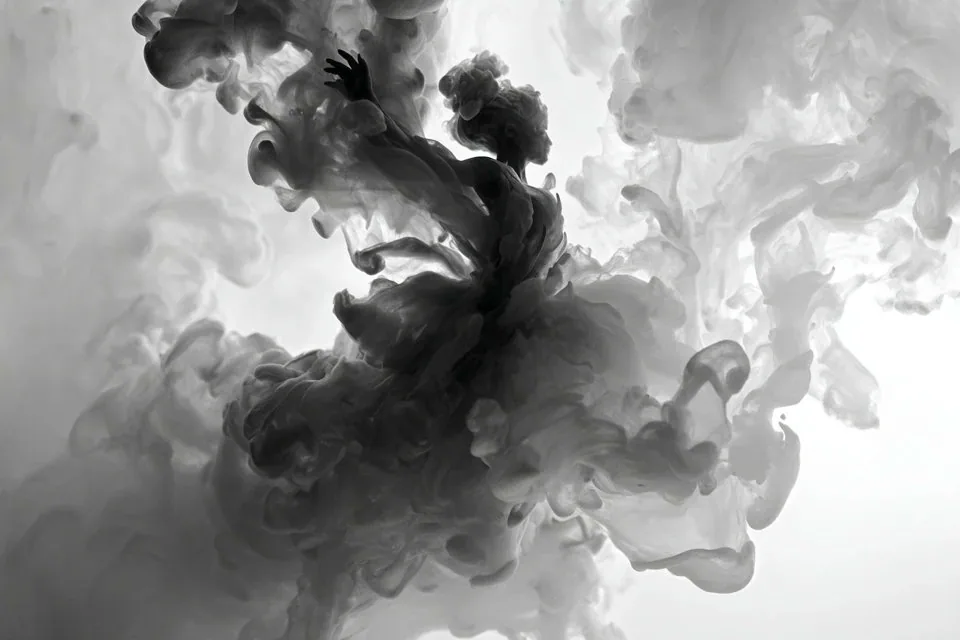 Black ink unfurling into fluid, organic currents